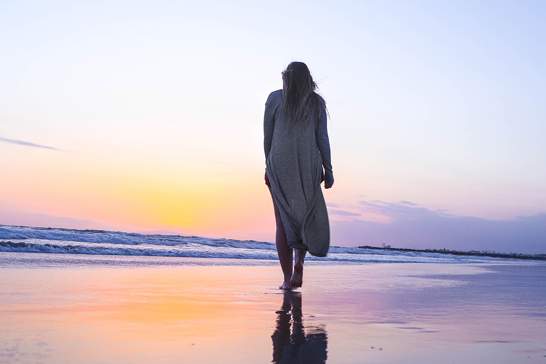 frau bei sonnenuntergang am strand